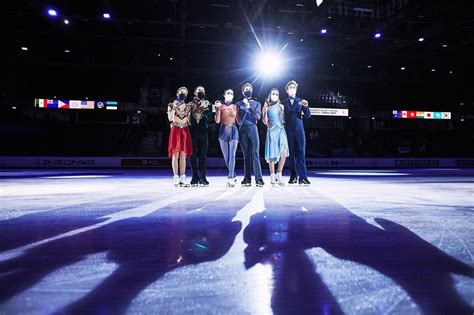 five people standing on an ice rink at night