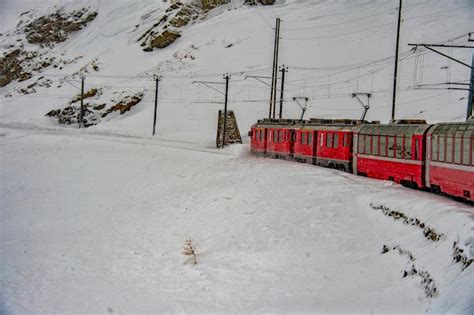 Premium Photo | Red train in the snow in swiss alps