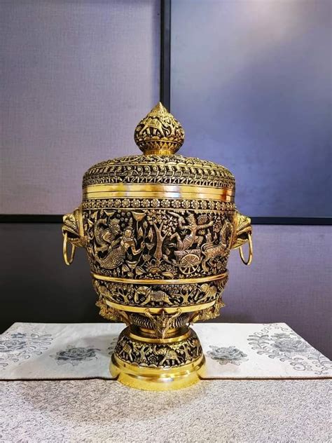 An Ornately Decorated Gold Vase Sitting On Top Of A Table