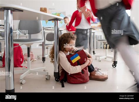 Petite fille ukrainienne triste assise sur le sol à l école concept d