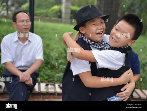 A pair of young Chinese twin boys hugs each other at the launch ...