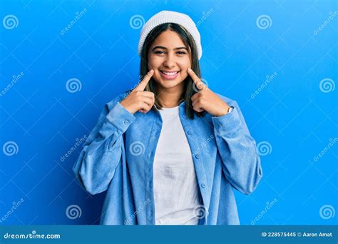 Joven Latina Con Una Linda Gorra De Lana Sonriendo Con Los Dedos De La Boca Abierta Apuntando Y