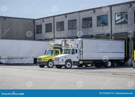 Affordable Middle Duty Rigs Semi Trucks With Refrigerated Box Trailers Loading Cargo Standing In