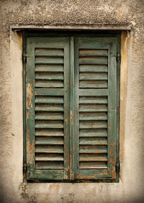 Two Old Windows With Closed Shutters On An Old House Stock Photo