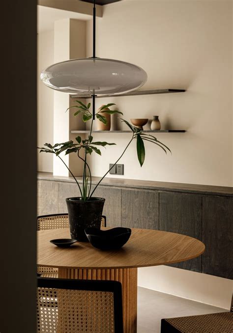 A Potted Plant Sitting On Top Of A Wooden Table Next To A Chair And Shelf