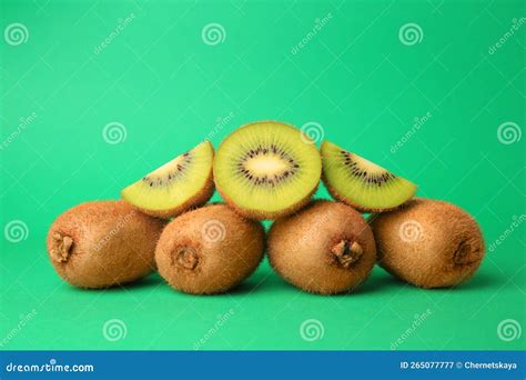 Heap Of Whole And Cut Fresh Kiwis On Green Background Stock Image