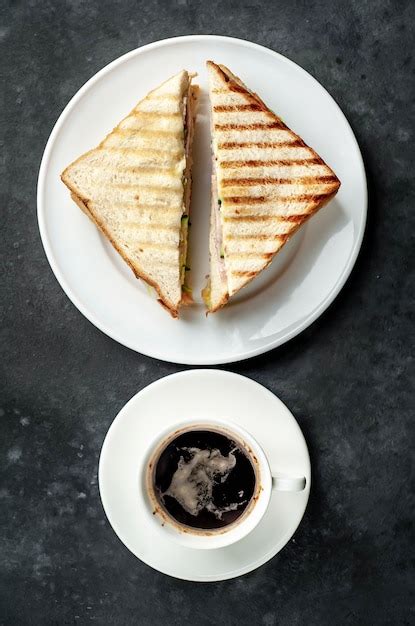 Café y sandwiches con jamón queso tomate lechuga y pan tostado