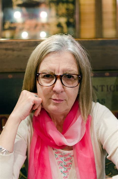 Mature Woman In Glasses Posing Confidently While Sitting Indoors Stock Photo Image Of