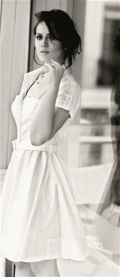 A Woman Standing In Front Of A Window Next To A Mannequin Wearing A Dress