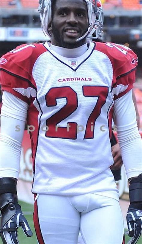 A Football Player Is Standing On The Field Wearing A Helmet And Holding