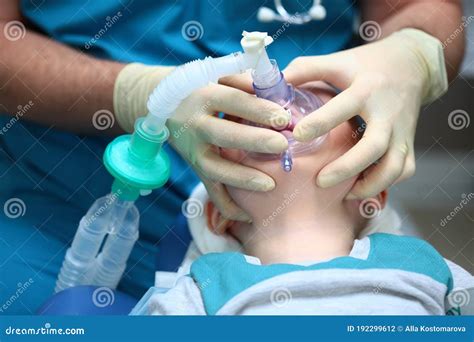 An Anaesthetist Holds A Breathing Mask On The Face Of A Small Boy