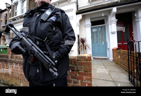 An Armed Police Officer Stands Guard Outside The London Home Of Home