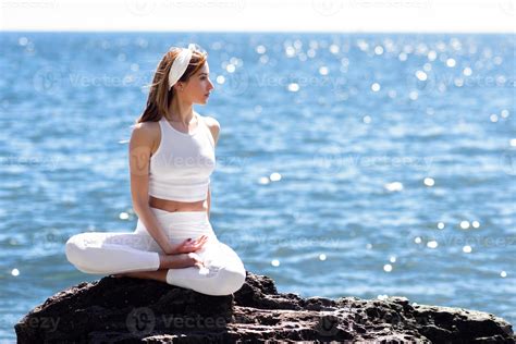 Young woman doing yoga in the beach wearing white clothes 5445110 Stock ...