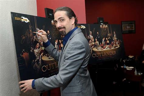 Composer Bear Mccreary Signs A Poster At The Outlander From Scotland