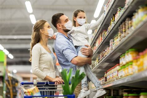 Familia Con Carrito De Compras Con Máscaras En El Supermercado Foto de