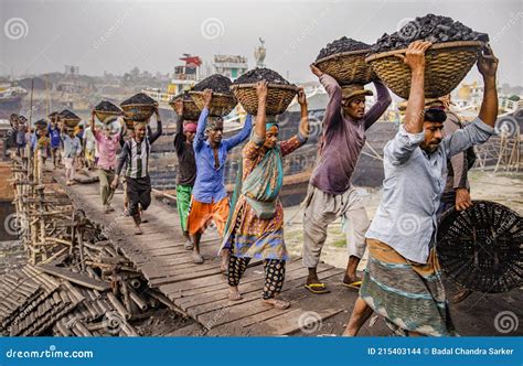 A Line Of Workers Carrying The Heavy Loads Of Coal In Baskets Editorial