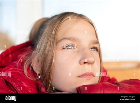 Gros plan portrait de jeune fille blonde à yeux verts Elle a mis son menton sur un bras