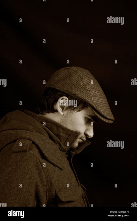 Side View Of A Man Wearing Hat And Jacket Deep In Thoughts Stock Photo