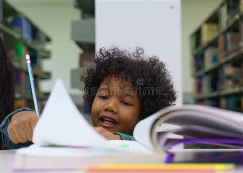 Little Boy Reading Book in the Library Stock Photo - Image of desk ...