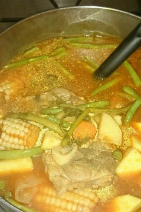 A Pot Filled With Meat And Vegetables On Top Of A Stove