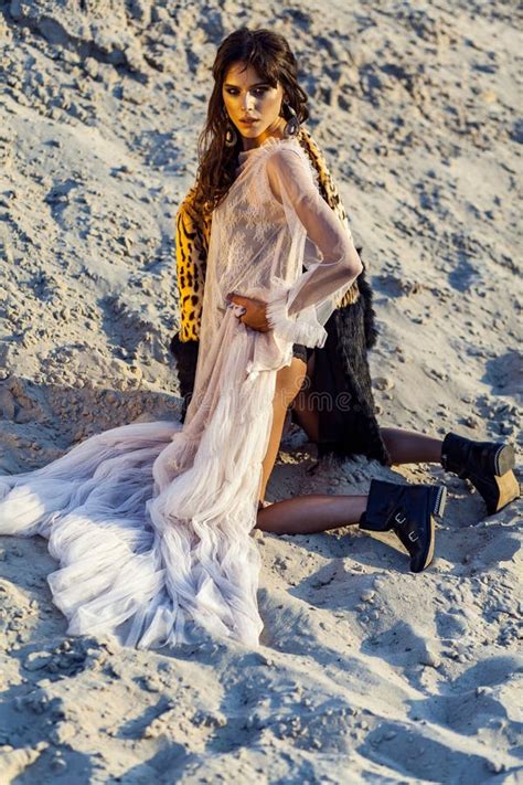 Attractive Brunette Woman In Translucent Beach Cover Up With Leopard Fur Coat And Black Boots