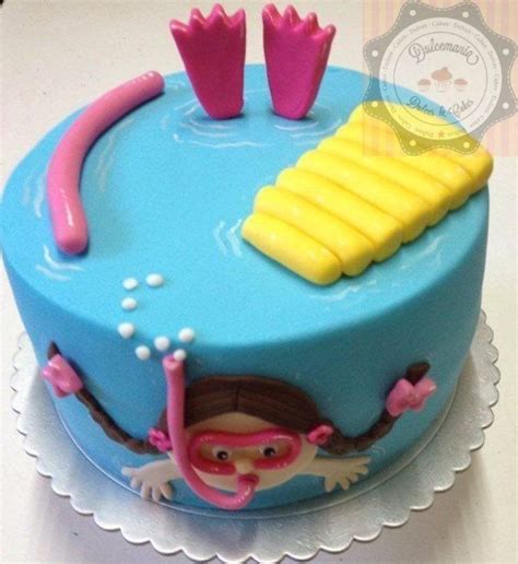 A Blue Cake With Yellow Icing And Pink Decorations