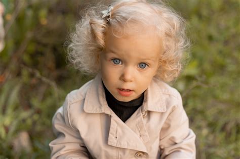 Retrato De Uma Menina Loira Cacheada Fofa Olhos Azuis Em Uma Capa