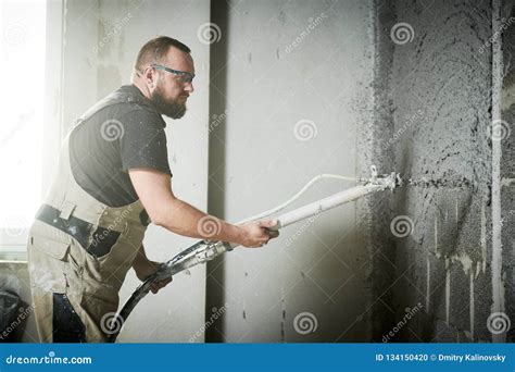 Plasterer Using Screeder Spraying Putty Plaster Mortar On Wall Stock