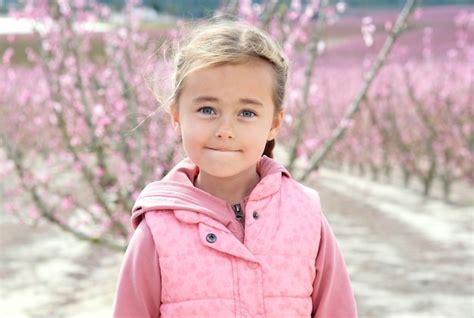 Premium Photo Portrait Of Cute Girl Standing Against Cherry Trees