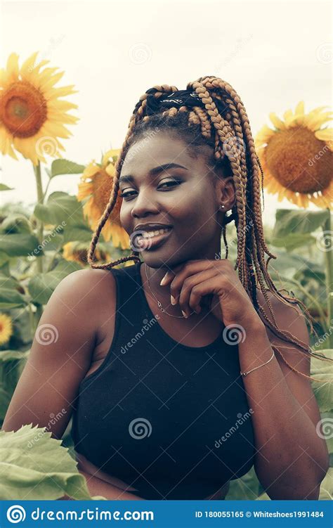 African American Girl In A Field Of Yellow Flowers At Sunset Stock