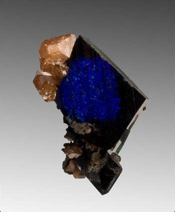 A Piece Of Blue Glass With Some Rocks Around It And One Rock On The