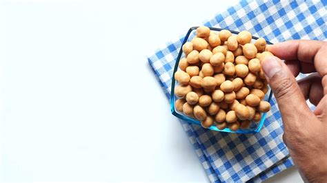 Adult takes Crunchy Soy Coated Roasted Chickpeas out of bowl for