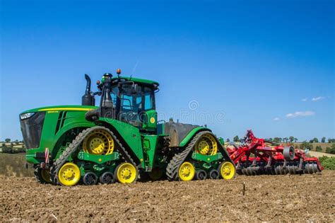 Tracteur Moderne De Caterpilla De John Deere Cultivant Le Champ Anglais