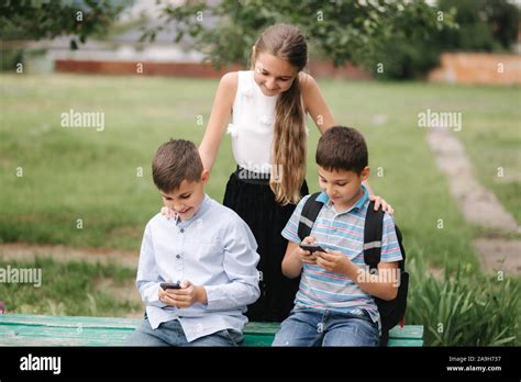 Two Boys And Girl Use Their Phones During School Breack Cute Boys