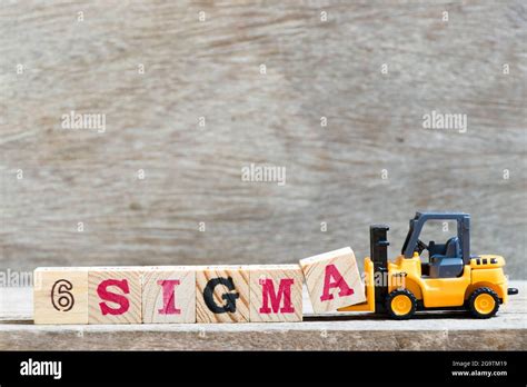 Toy Forklift Hold Letter Block A To Complete Word Sigma On Wood