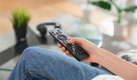 Premium Photo Woman Sitting On Sofa And Hand Holding TV Remote