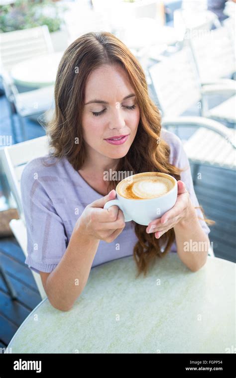Pretty Brunette Enjoying A Cappuccino Stock Photo Alamy