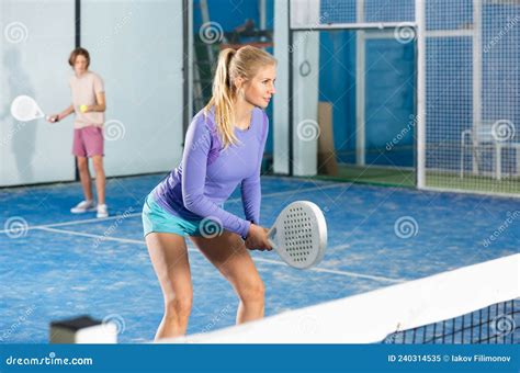 Sporty Woman Padel Player Hitting Ball With A Racket On Hard Court