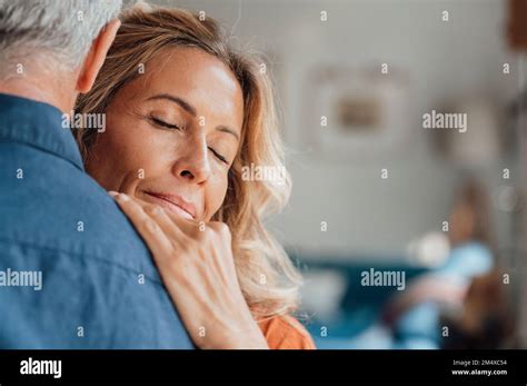 Mature Woman With Eyes Closed Embracing Man At Home Stock Photo Alamy