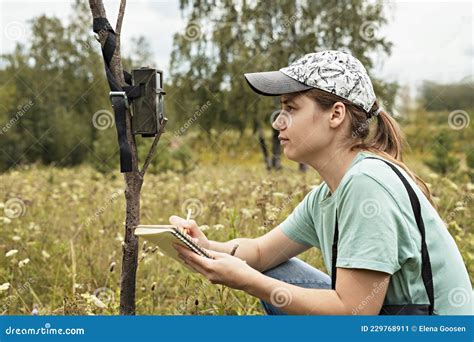 Young Woman Scientist Zoologist Writing Down Data From Trap Camera To