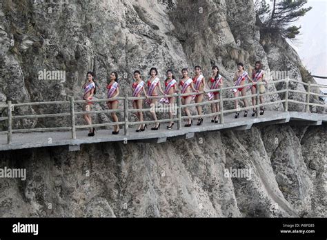 Bikini Dressed Models Walk In High Heels On A Boardwalk On The Cliff Of A Mountain During A