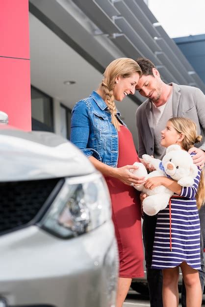 Madre Padre E Hijo Comprando Un Carro En El Concesionario Foto Premium