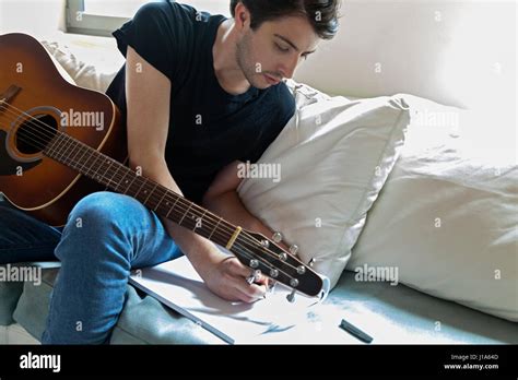 Joven músico escribiendo canciones en una guitarra acústica Fotografía ...