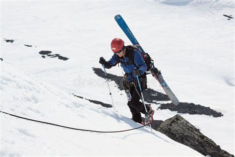 Alpinista Dello Sci Che Scala Sulla Roccia Con Gli Sci Attaccati Allo