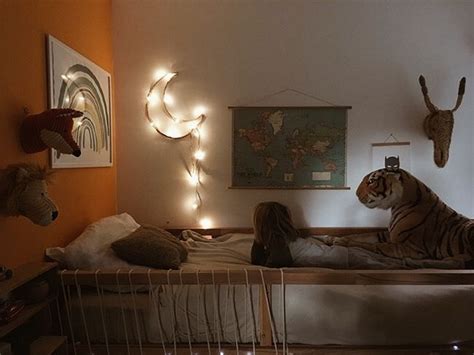 A Woman Laying On Top Of A Bed Next To A Stuffed Tiger And Deer Head