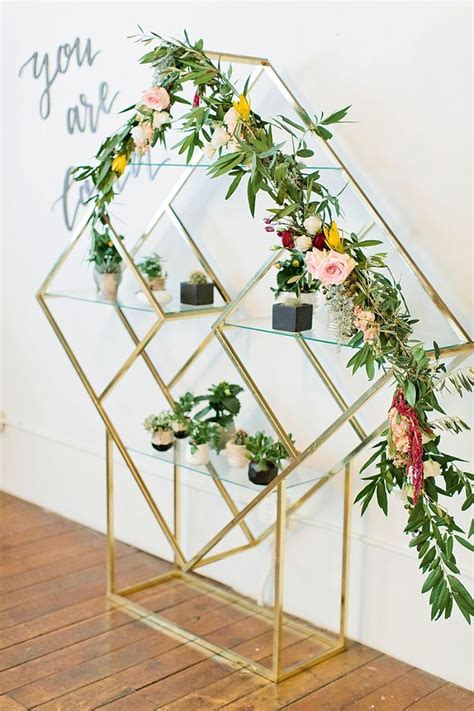 An Arrangement Of Flowers And Greenery Is Displayed On A Shelf