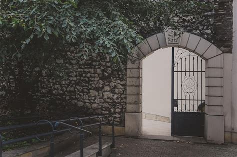 Premium Photo Iron Arched Gate In An Old Stone Wall With Ivy