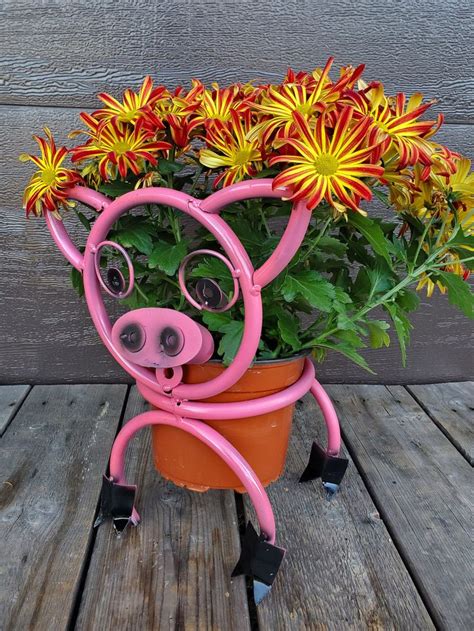 A Pink Pig Planter With Flowers In It