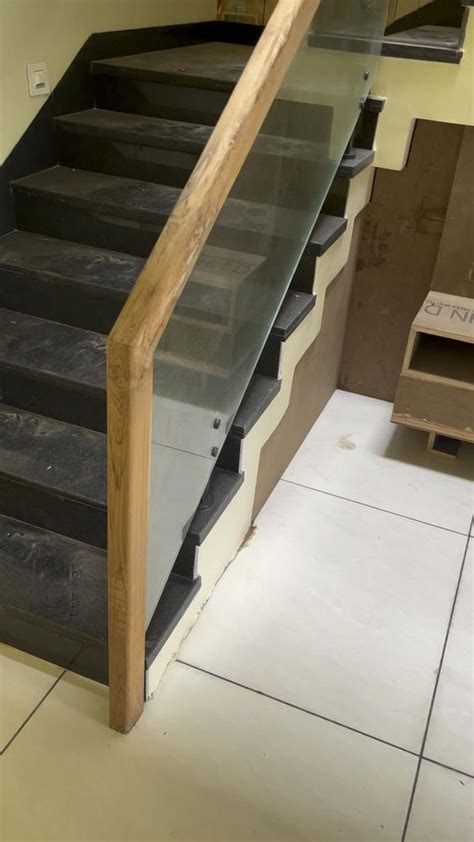 A Set Of Stairs With Glass Railings And Wood Handrail