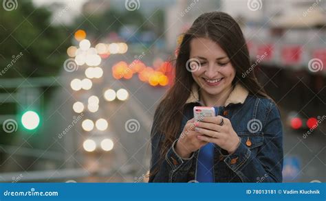 Happy Smiling Pretty Woman Uses A Smartphone Standing On The Bridge